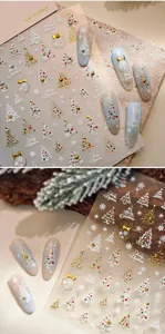 Macro detail of Christmas nail stickers with 3D embossed trees and snowflakes