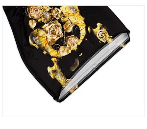 Detailed macro view of black fabric with golden rose patterns and double-stitch hem
