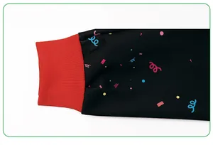 Detail of red ribbed knit cuffs on black long-sleeve sweatshirt with colorful patterns