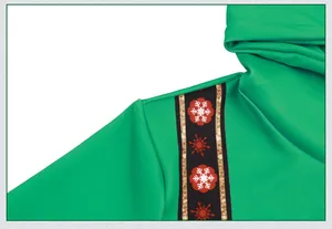 Détail d'un sweat à capuche vert de Noël avec ruban d'épaule décoratif et motifs flocons
