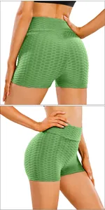 Detail of high-waist green scrunch butt yoga shorts with bubble textured fabric