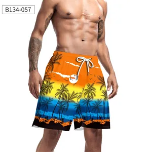 Detail of men's orange beach shorts with tropical palm tree print and elastic drawstring