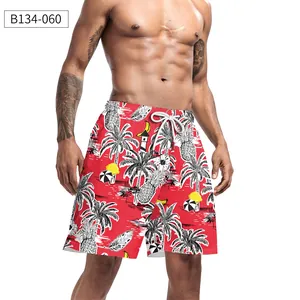 Detail of red beach shorts featuring tropical palm prints and adjustable white drawstring