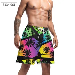 Detail of men's beach shorts featuring tropical palm prints and vibrant rainbow gradient