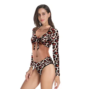 Detail of two-piece leopard print swimsuit featuring long sleeve v-neck tie-up top and high waist bottom