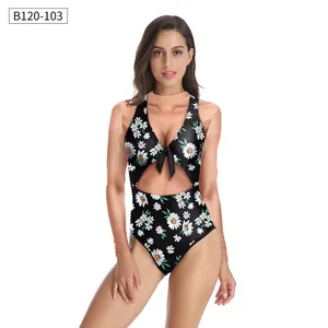 Detail of floral one-piece swimsuit with V-neck, front bow tie and waist cut-out