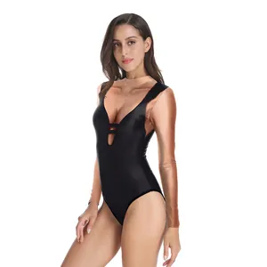 Detail view of glossy black metallic leotard featuring a deep V-neck and decorative straps