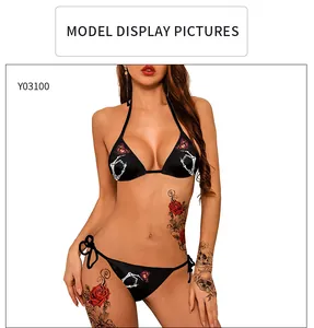 Detail eines schwarzen Bikinis mit weißem Knochenhand- und rotem Schmetterlingsdruck