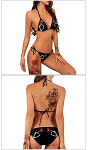 Detail eines schwarzen Bikinis mit weißem Skeletthand- und rotem Schmetterlingsdruck