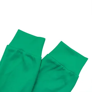 Nahaufnahme der smaragdgrünen Sweatshirt-Manschette mit elastischem Rippbündchen und flacher Naht