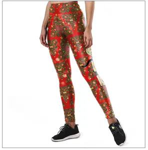 Detailed view of red Christmas leggings featuring festive green tree and star patterns