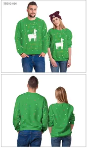 Detailed view of green Christmas sweatshirt featuring llama print and festive fa-la-la text