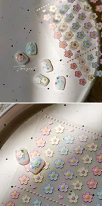 Macro shot of embossed 3D frangipani flower nail stickers with pastel colors and matte finish
