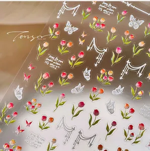 Detailed macro view of 3D embossed tulip flower and butterfly nail art stickers