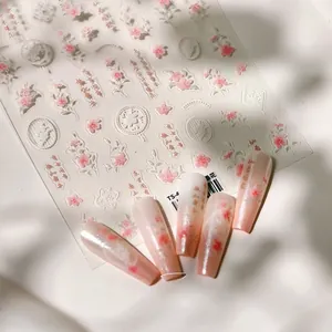 Macro shot of 5D embossed floral nail stickers with pink cherry blossoms and vintage frames