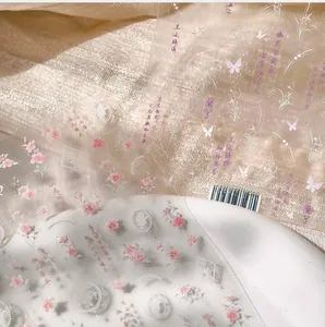 Close-up of 5D embossed floral nail stickers with Chinese calligraphy and pink flowers