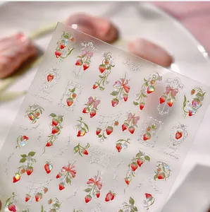 Macro detail of 5D strawberry nail art stickers with embossed textures and glitter