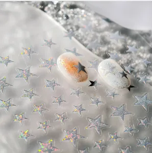 Macro shot of laser holographic star nail art stickers on display artificial nails