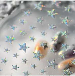 Detailed macro view of holographic star nail stickers with laser glitter effect