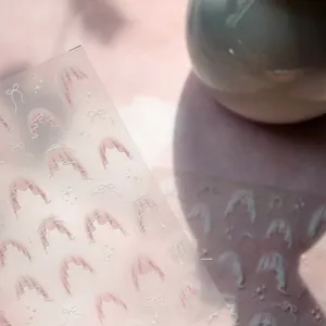 Detailed view of 5D white lace nail stickers with bows and stars on frosted film