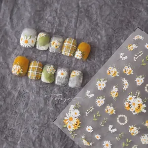 Macro detail of yellow daisy and sunflower nail art stickers with plaid accent pattern