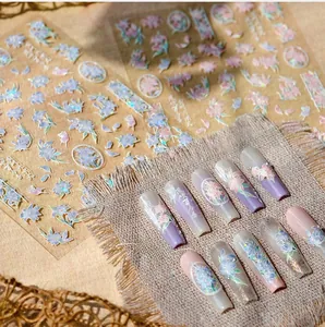 Macro shot of pink floral holographic nail stickers and pearlescent butterfly nail art