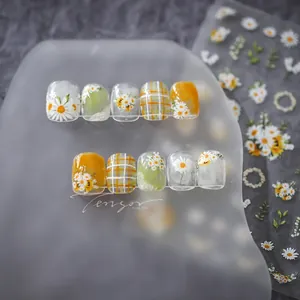 Detailed view of daisy and plaid press-on nails with sunflower decals and glossy finish