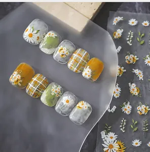 Detailed view of spring daisy and plaid nail stickers on ten matte display tips