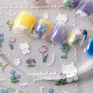 Makroaufnahme von 5D-geprägten Blumen- und Katzen-Nagelstickern in Pastelltönen