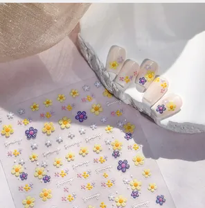Nahaufnahme von geprägten Nagelaufklebern mit Frühlingsblumen und Sunny-Schriftzug