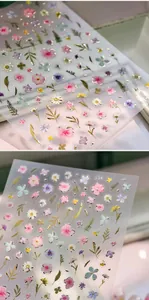Macro detail of embossed 3D flower nail stickers with gold foil floral patterns