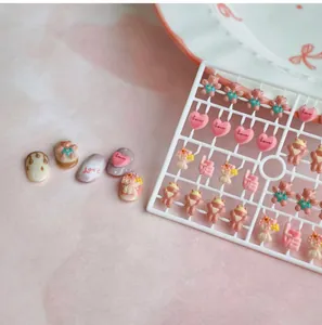 Detailed view of cute resin 3D bear and love heart charms for nail art decoration