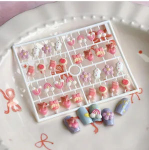 Vue macro de breloques nail art en résine 3D avec ours mignons, nœuds et motifs arc-en-ciel