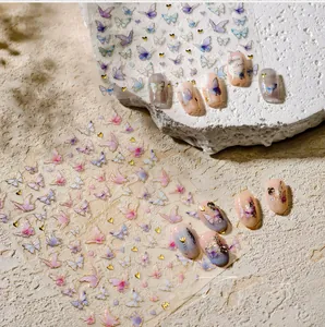 Dettaglio macro di adesivi per unghie farfalla 3D dorati con accenti viola e blu