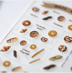 Macro shot of 3D embossed European bread nail art stickers with croissant and pretzel patterns