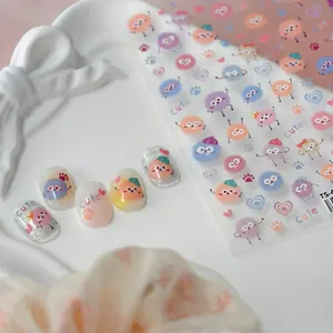 Cute 5D cartoon nail stickers for kids featuring colorful monsters and hearts on white tray