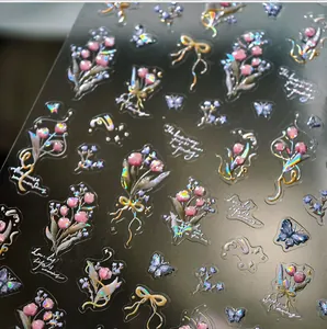 Dettaglio di adesivi per unghie 3D olografici con mazzi di fiori rosa e farfalle blu