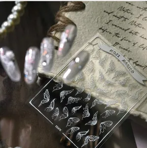 Detail view of 3D white angel wings and butterfly nail stickers on vintage background