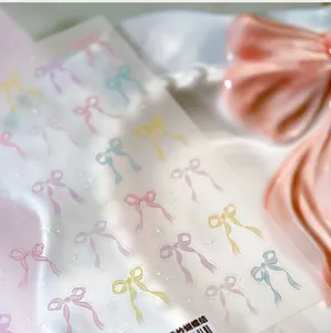 Macro shot of semi-transparent matte nail stickers with colorful ribbon bow patterns