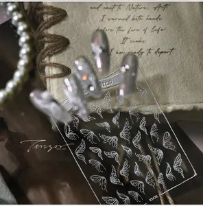 Macro shot of white angel wing nail stickers KX470 with 3D texture on transparent film