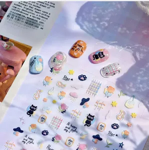 Detail of embossed nail stickers featuring black cats and flowers in pastel macaron colors