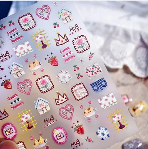Détail macro de stickers ongles 3D en relief avec motifs chat, cœur et rose