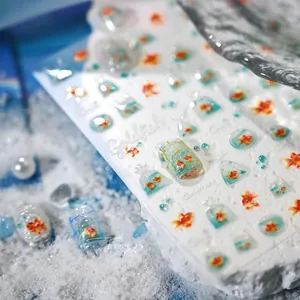 Detailed close-up of 3D goldfish nail art stickers with translucent water droplet effects
