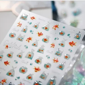 Close-up of 3D embossed goldfish nail stickers with stereoscopic water drop design