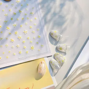Detailed view of daisy nail stickers KX477 applied on tips with matte floral patterns