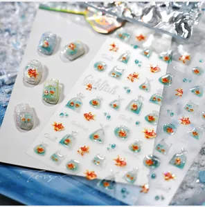 Detail view of 3D goldfish nail art stickers with clear shell and glass effect textures