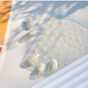 Macro detail of KX47 daisy nail stickers with delicate white and yellow floral patterns