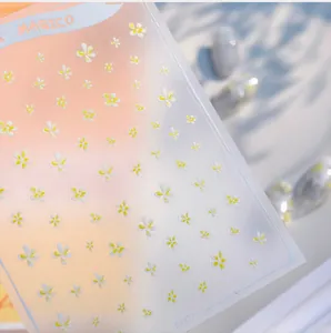 Macro detail of white daisy nail art stickers with yellow centers on clear KX477 sheets