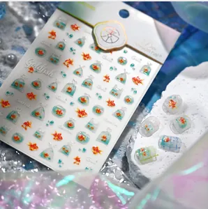 Detailed close-up of goldfish nail stickers with realistic 3D water bag and bubble patterns