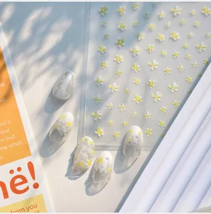 Detailed macro view of daisy and lace nail art stickers on model nails, model KX477